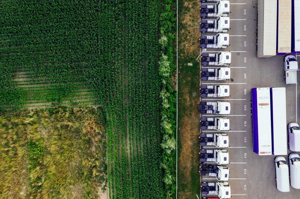 Trucks lined up beside a distribution center and farmland