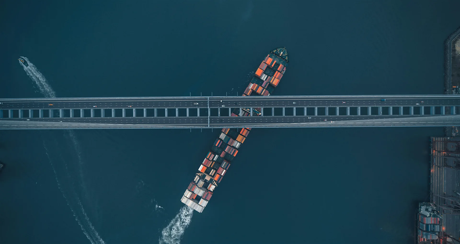 Container ship passing beneath a bridge, connecting sea and road networks